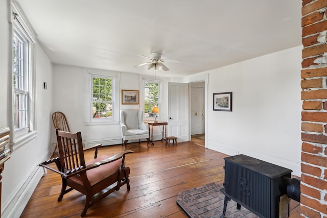 living area with baseboards, a ceiling fan, and hardwood / wood-style flooring