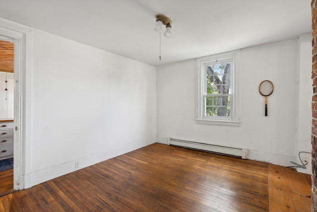 empty room featuring a baseboard heating unit and hardwood / wood-style flooring