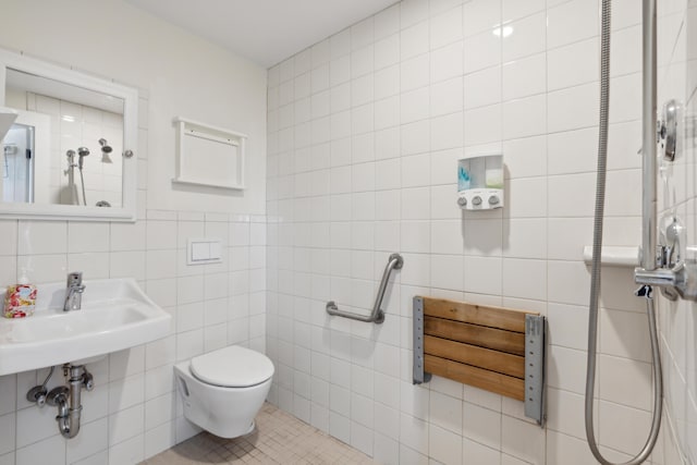 bathroom with tile patterned flooring, toilet, tile walls, and a sink