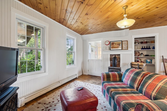 living room with built in shelves, a baseboard heating unit, wood ceiling, a wood stove, and wood finished floors