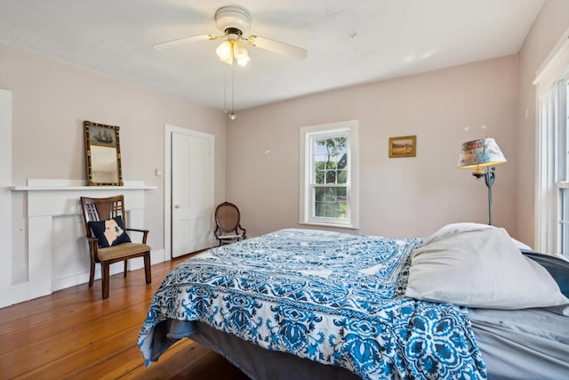 bedroom with ceiling fan, baseboards, and wood finished floors