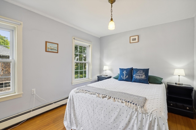 bedroom featuring wood finished floors and a baseboard radiator