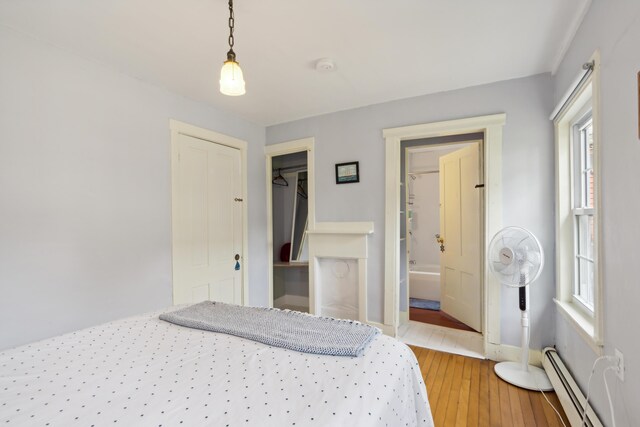 bedroom featuring a closet, hardwood / wood-style flooring, and a baseboard radiator