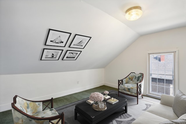 carpeted living area with vaulted ceiling and baseboards