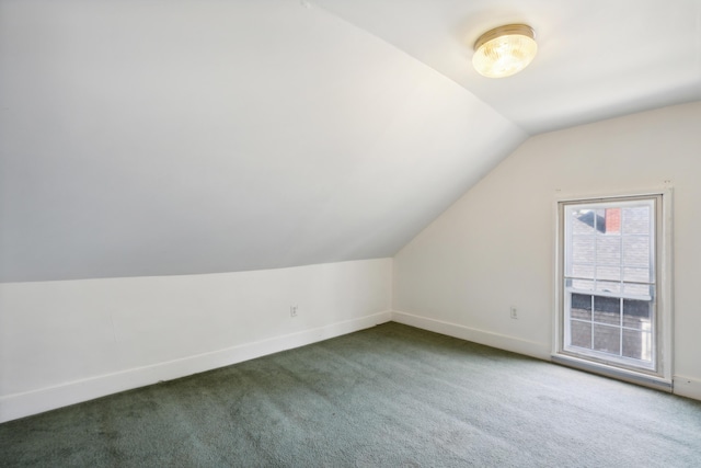 additional living space with baseboards, carpet, and vaulted ceiling