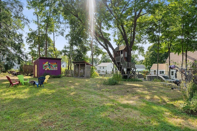 view of yard featuring stairway, fence, an outdoor structure, and a shed