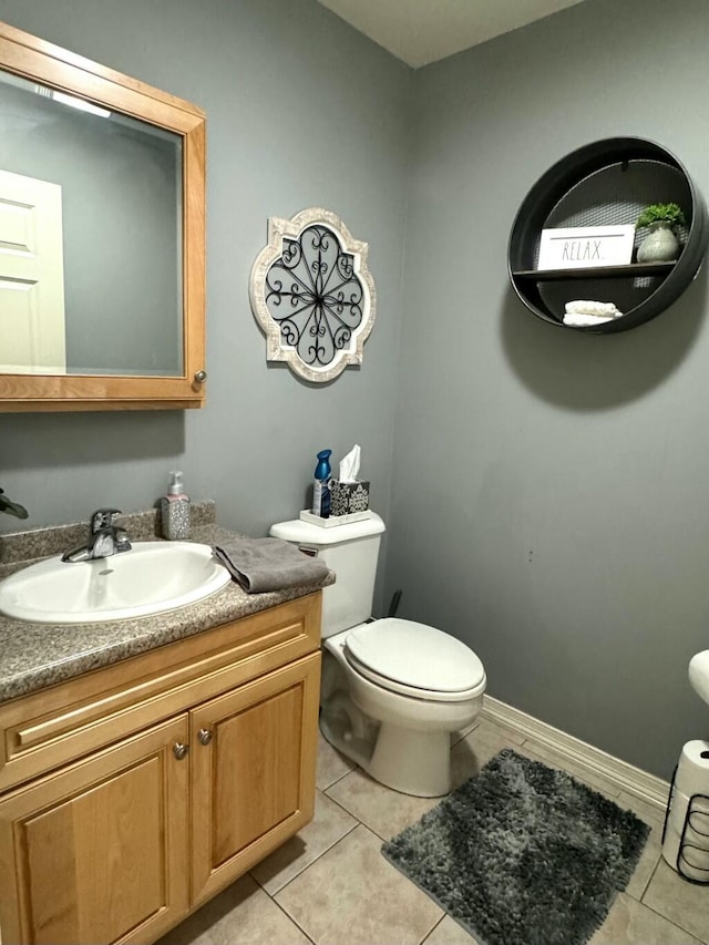 bathroom featuring vanity, tile patterned flooring, toilet, and baseboards