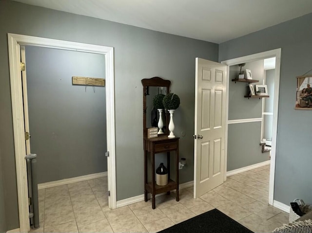 entryway featuring baseboards and light tile patterned floors