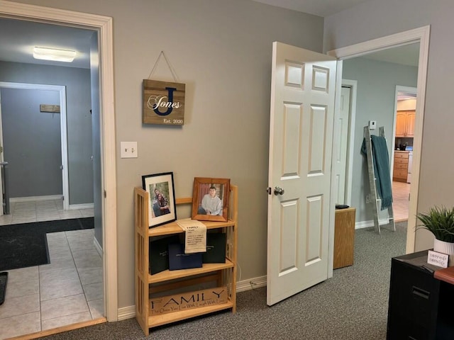 hallway with tile patterned floors and baseboards