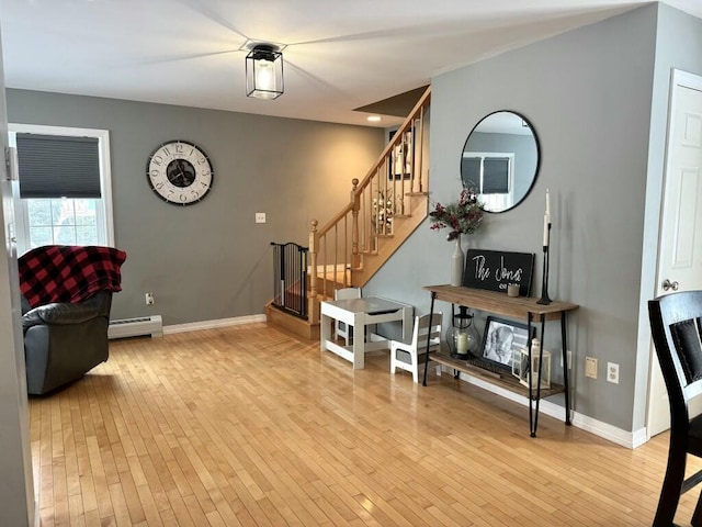 interior space with light wood-style floors, a baseboard radiator, stairs, and baseboards