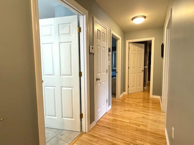 hallway with baseboards and light wood-style floors