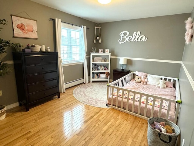 bedroom featuring a baseboard radiator and wood finished floors