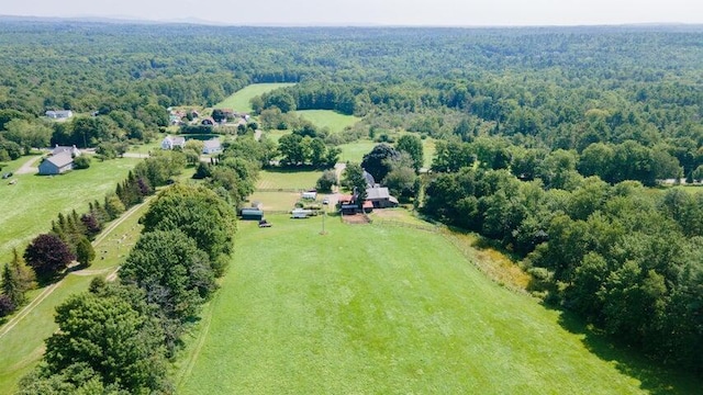 birds eye view of property featuring a wooded view and a rural view