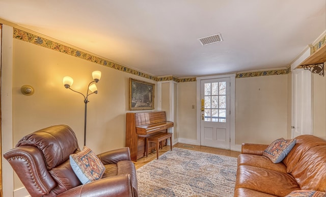 living room featuring baseboards, visible vents, and light wood finished floors