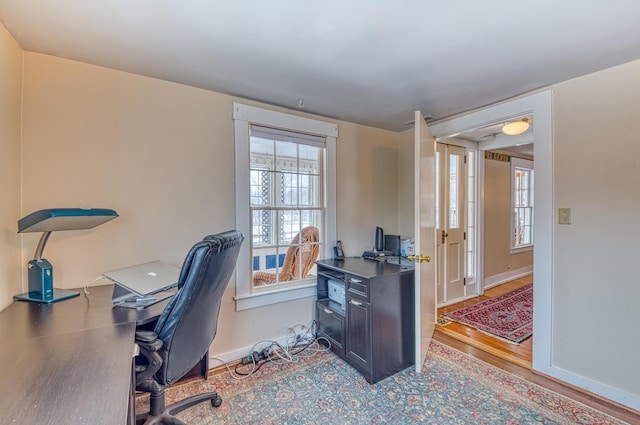 office featuring plenty of natural light, baseboards, and wood finished floors