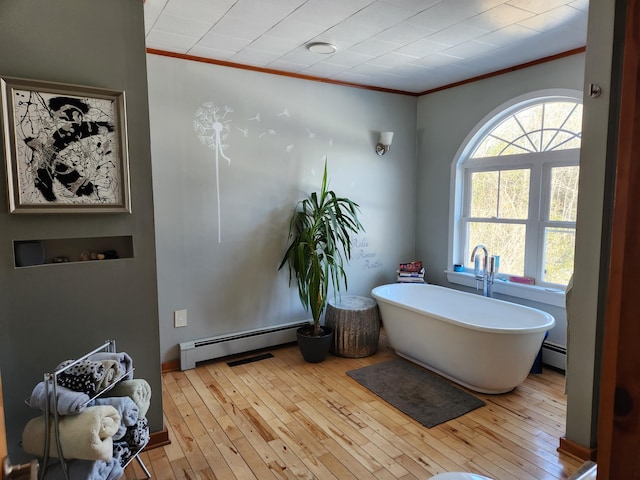 full bathroom with crown molding, a baseboard heating unit, and wood-type flooring