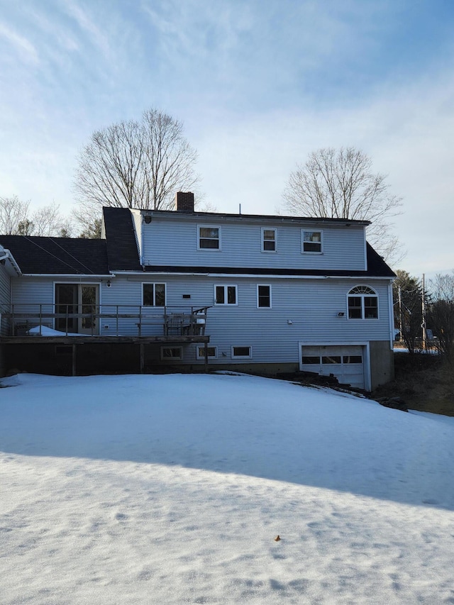 back of property with a deck and a chimney