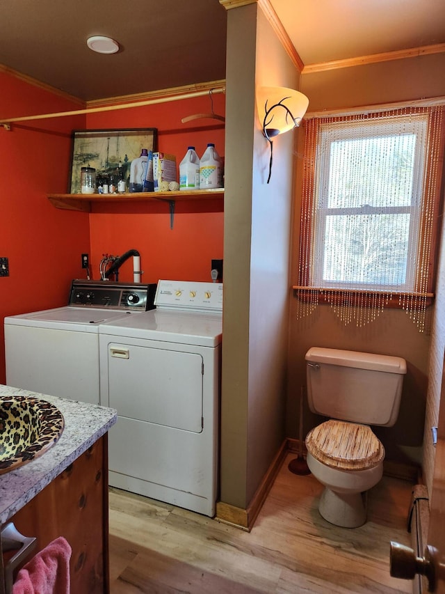 laundry area with independent washer and dryer, baseboards, laundry area, ornamental molding, and light wood-type flooring