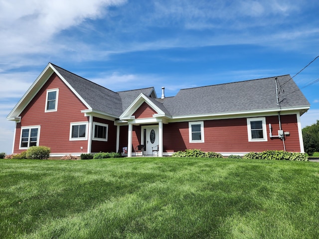 view of front of home with roof with shingles and a front lawn