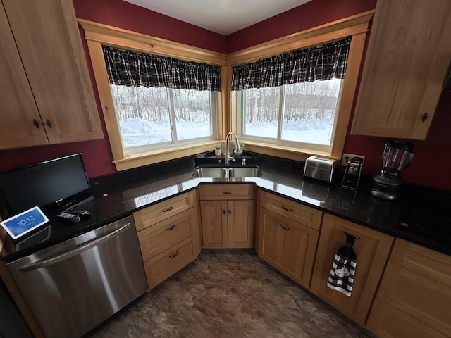 kitchen featuring dishwasher, light brown cabinetry, dark countertops, and a sink