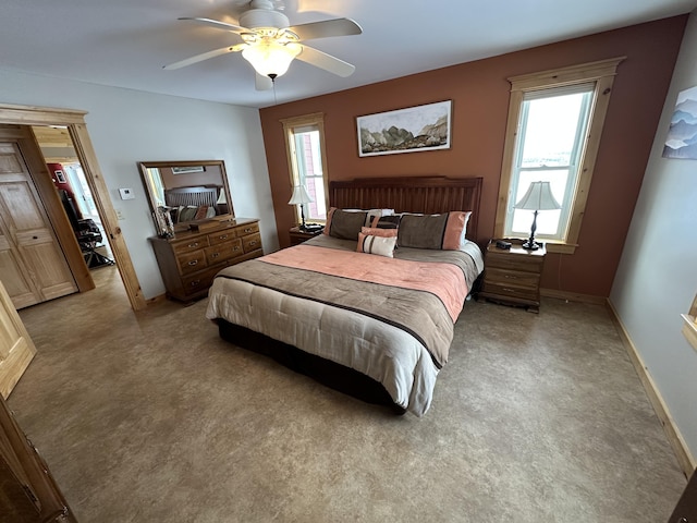 bedroom featuring baseboards, ceiling fan, and light colored carpet