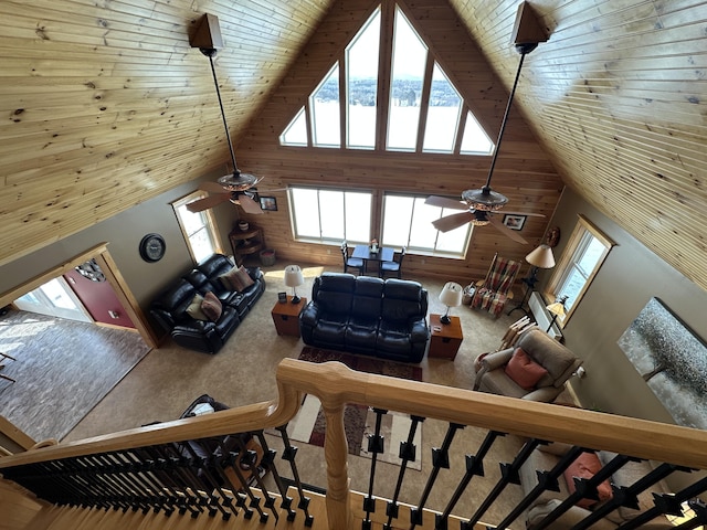 living area featuring high vaulted ceiling, wooden ceiling, carpet flooring, and wooden walls