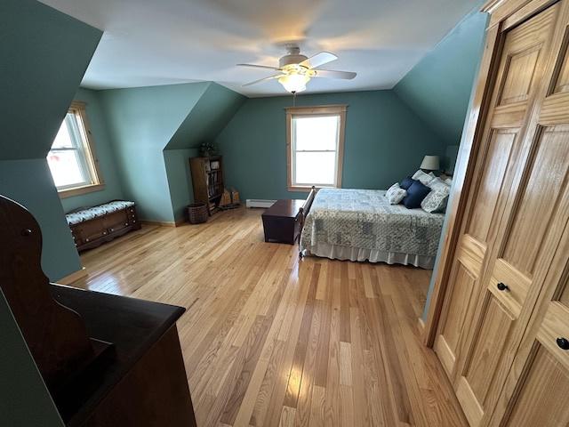 bedroom with light wood-style floors, multiple windows, and vaulted ceiling