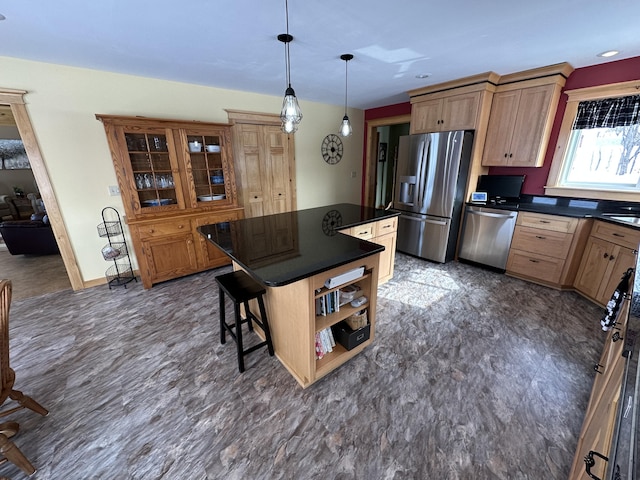 kitchen with dark countertops, a kitchen island, appliances with stainless steel finishes, and open shelves