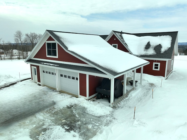 snow covered garage with a detached garage