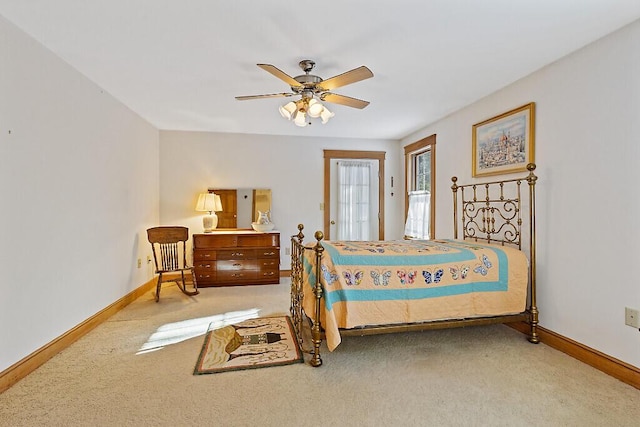 carpeted bedroom with ceiling fan and baseboards