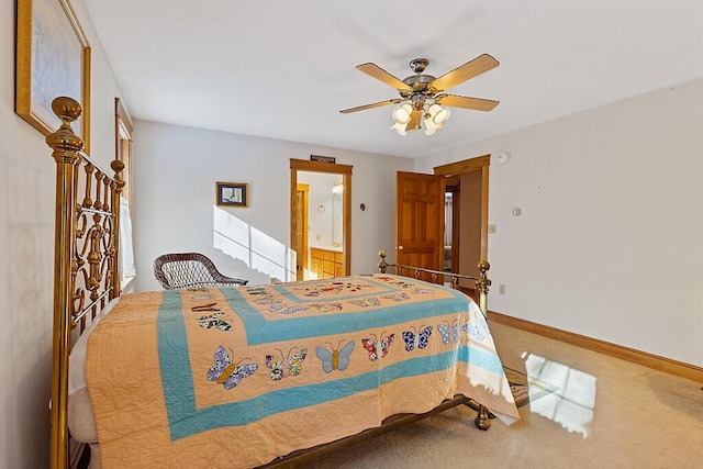 carpeted bedroom featuring a ceiling fan, ensuite bath, and baseboards