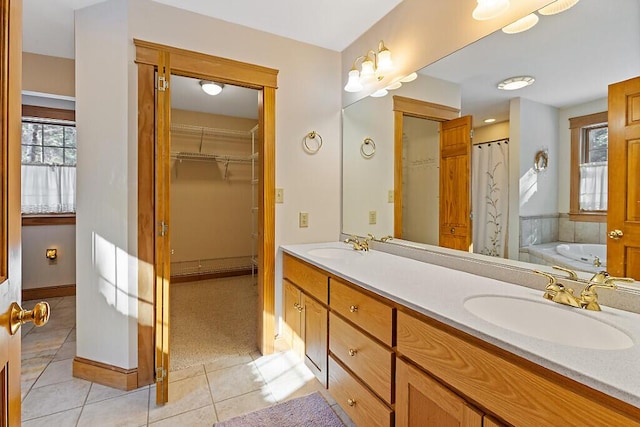 bathroom featuring a garden tub, double vanity, tile patterned flooring, and a sink