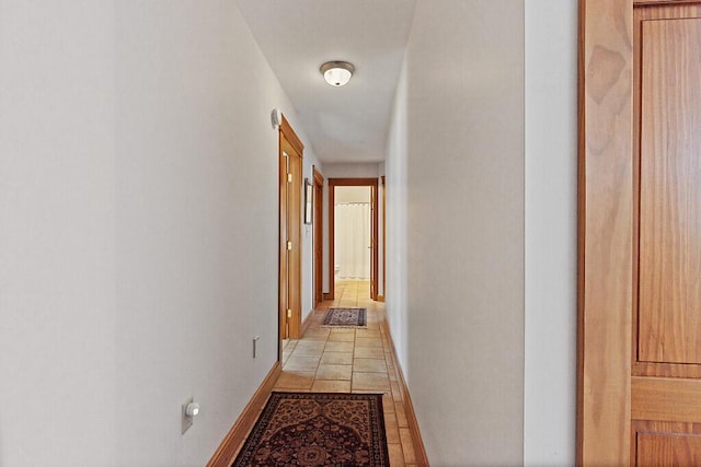 hallway with baseboards and light tile patterned flooring