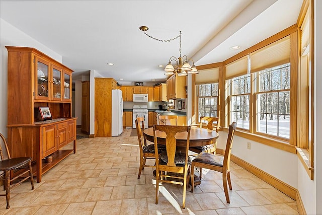 dining area with baseboards, recessed lighting, and an inviting chandelier