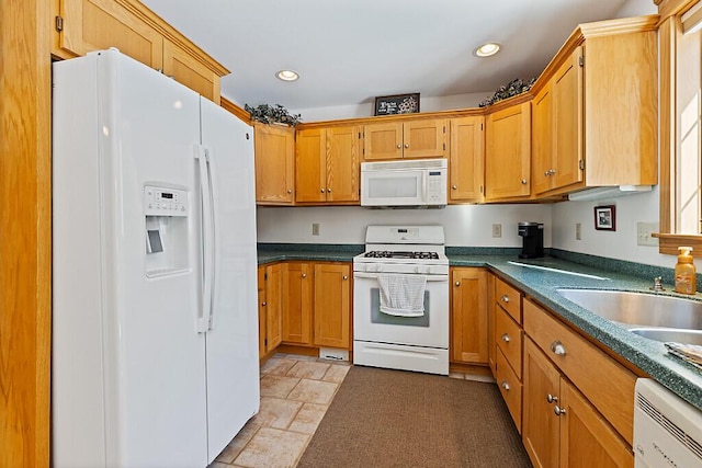 kitchen featuring recessed lighting, white appliances, a sink, brown cabinets, and dark countertops