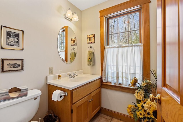 bathroom featuring baseboards, vanity, and toilet