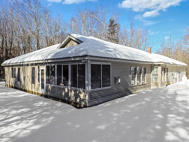 exterior space with a sunroom and a chimney