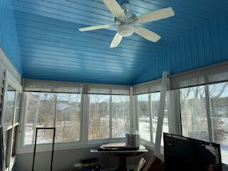 sunroom / solarium with vaulted ceiling and a ceiling fan