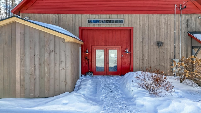 snow covered property entrance with french doors