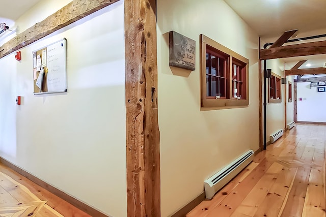 corridor featuring a baseboard heating unit and light wood-type flooring