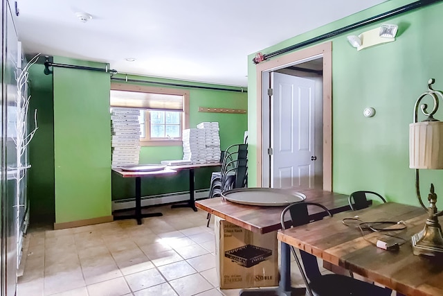 home office featuring light tile patterned floors, a baseboard radiator, and baseboards