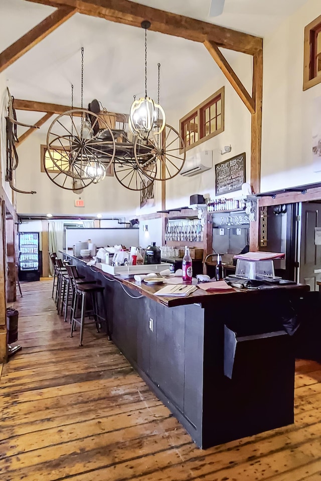 kitchen featuring vaulted ceiling with beams, a notable chandelier, and wood finished floors