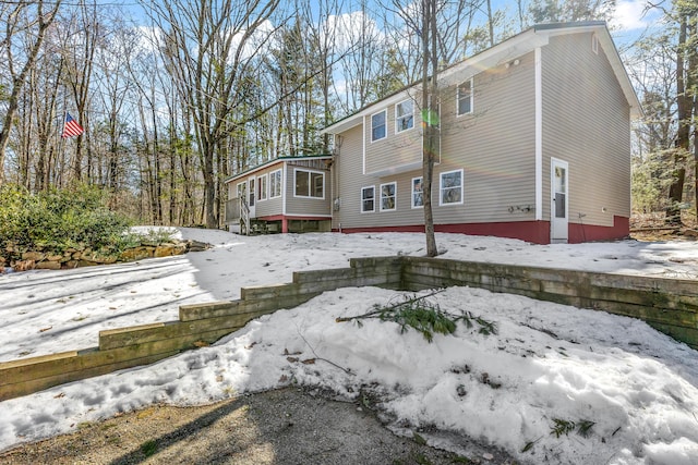 view of snowy exterior featuring a sunroom