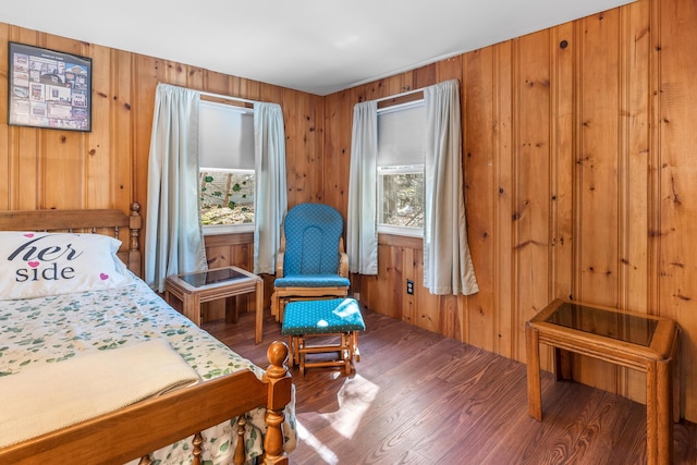 bedroom with wood finished floors and wood walls