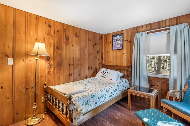 bedroom with wood walls and wood finished floors