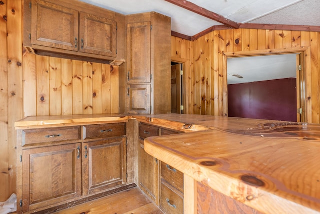 kitchen featuring wooden walls, light wood-style floors, and butcher block countertops