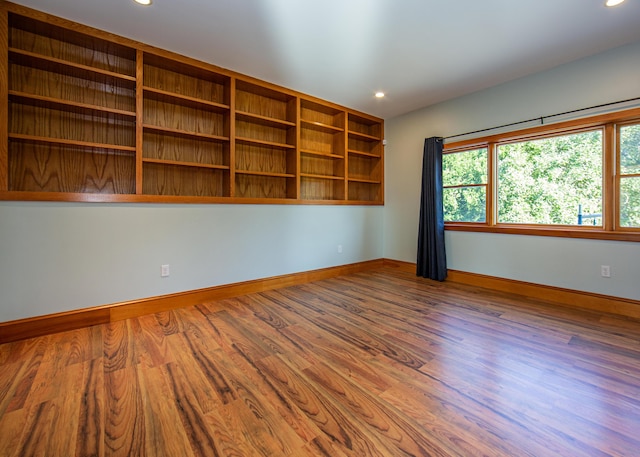 unfurnished room with baseboards, wood finished floors, and recessed lighting