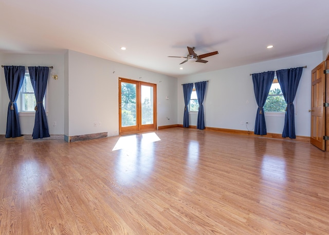 empty room featuring light wood-style flooring, a wealth of natural light, and baseboards