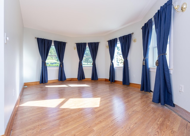 unfurnished room featuring baseboards and wood finished floors