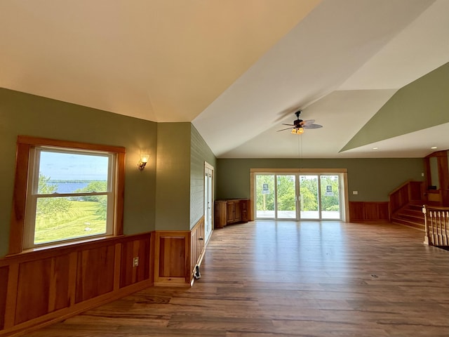 547 Mariaville Rd, Ellsworth, ME 04605 - unfurnished living room with a wainscoted wall, a ceiling fan, vaulted ceiling, wood finished floors, and stairs
